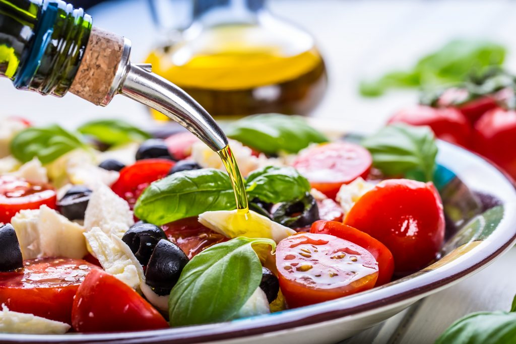 Stock image of salad with oil, tomato's, olives, basil and more